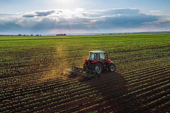 Tractor cultivating field at spring