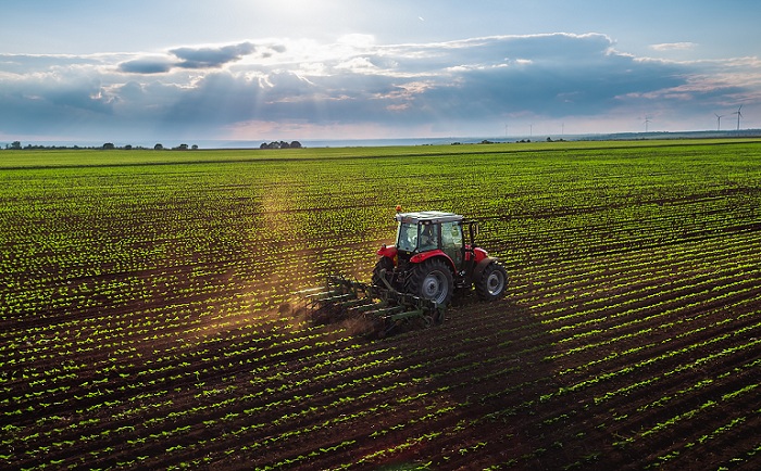 Tractor cultivating field at spring