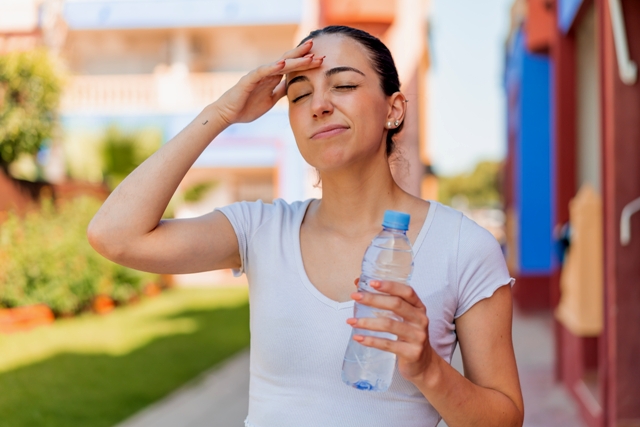 Young pretty woman with a bottle of water at outdoors