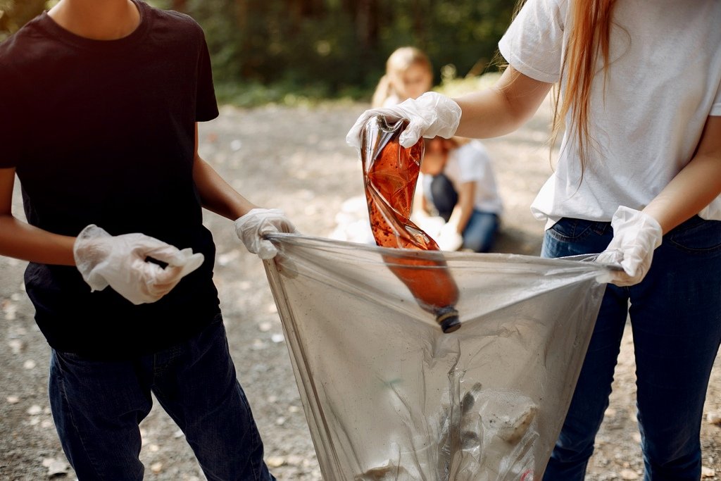 Children collects garbage in garbage bags in park
